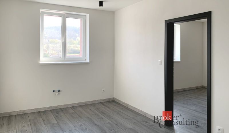 Innenraum einer Einzimmerwohnung mit Holzboden und weißen Wänden.