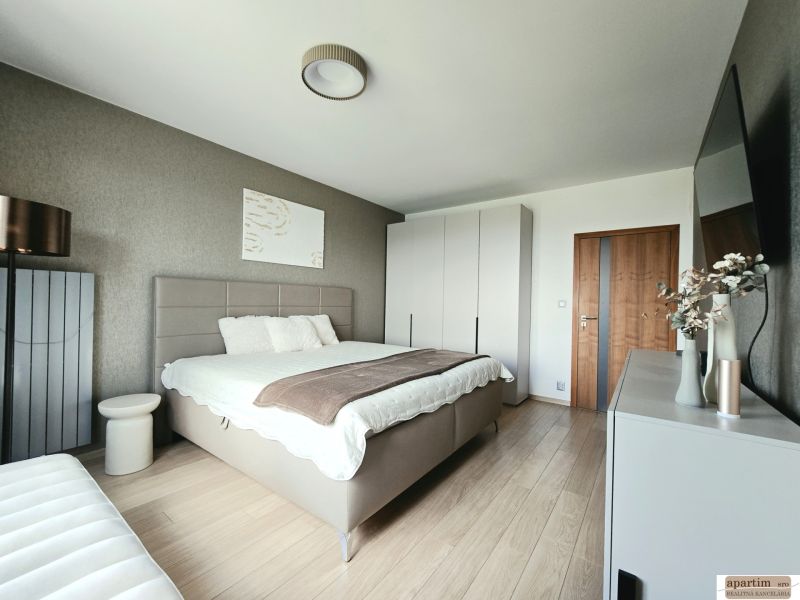 Schlafzimmer in einer 4-Zimmer-Wohnung mit Bett, Schrank und Boden in Holzoptik.