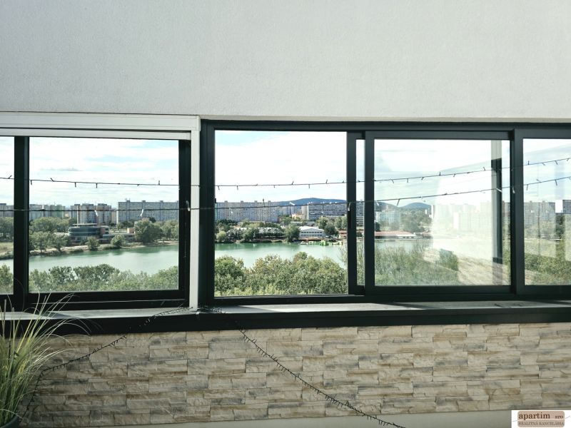 Blick von der Antolska-Straße auf den See in Petržalka durch die großen Fenster einer 4-Zimmer-Wohnung.