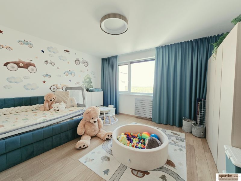 Kinderzimmer in einer 4-Zimmer-Wohnung mit Holzboden, Spielzeug und Wanddekoration.