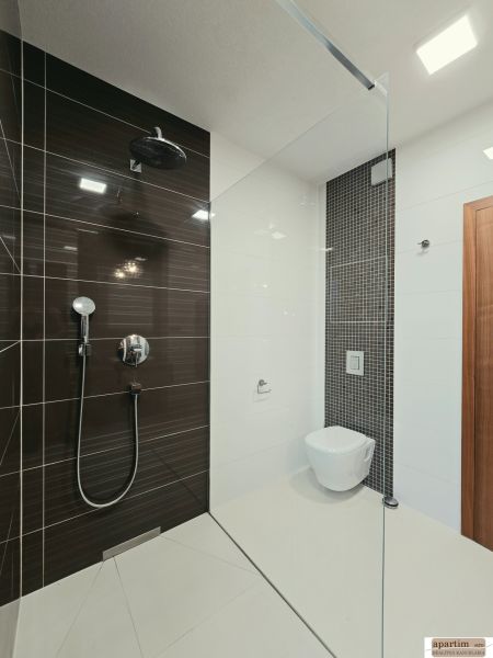 Badezimmer mit Duschkabine und hängendem WC in einer 4-Zimmer-Wohnung.