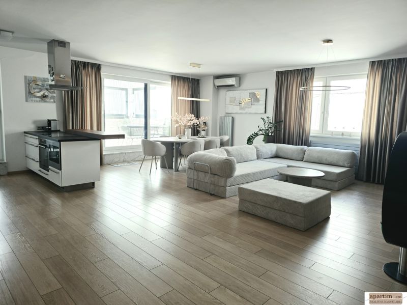 Wohnzimmer mit Küchenzeile, Boden mit Holzdekor, geräumiges Sofa, 4-Zimmer-Wohnung.