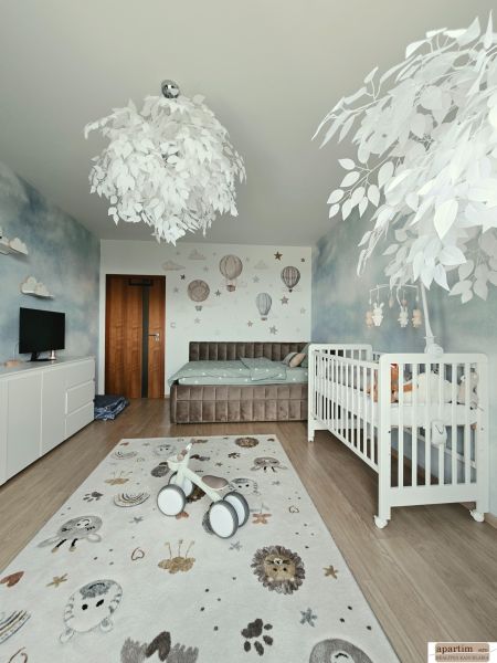 Kinderzimmer in einer 4-Zimmer-Wohnung mit Kinderbett, dekorativem Teppich und Boden mit Holzdekor.