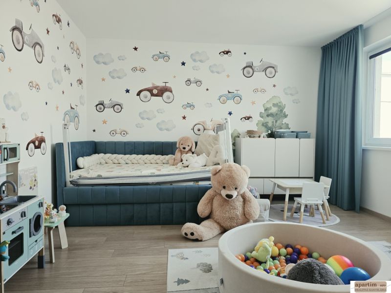 Kinderzimmer mit Spielzeug, blauem Bett, Tapete mit Autos und Boden mit Holzdekor.