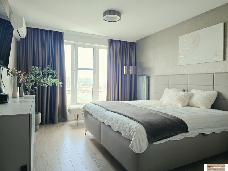 Schlafzimmer in einer 4-Zimmer-Wohnung mit Holzboden und großem Fenster.
