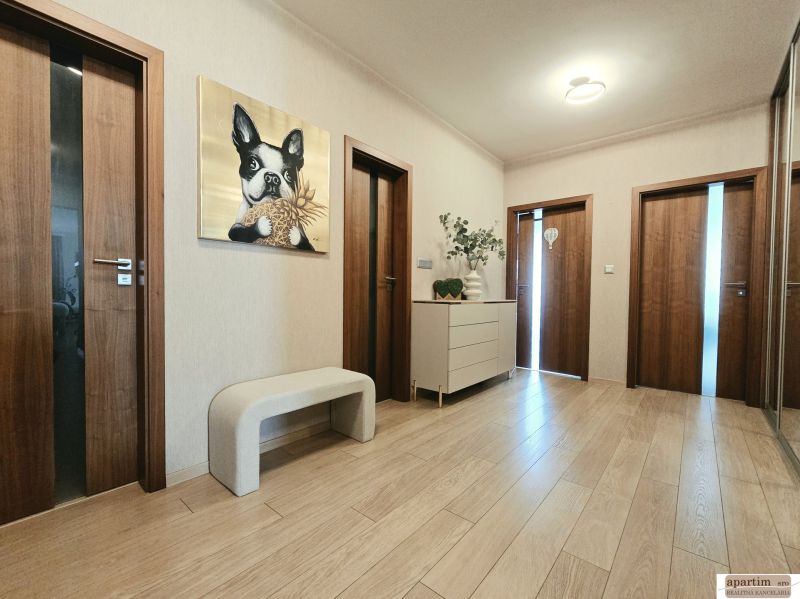 Flur in einer 4-Zimmer-Wohnung mit einem Bild eines Hundes, Holzboden und Möbeln.