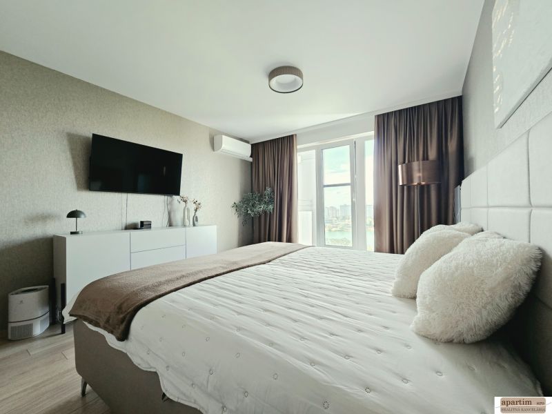 Stilvolles Schlafzimmer in einer 4-Zimmer-Wohnung mit Holzboden und Blick durch ein großes Fenster.
