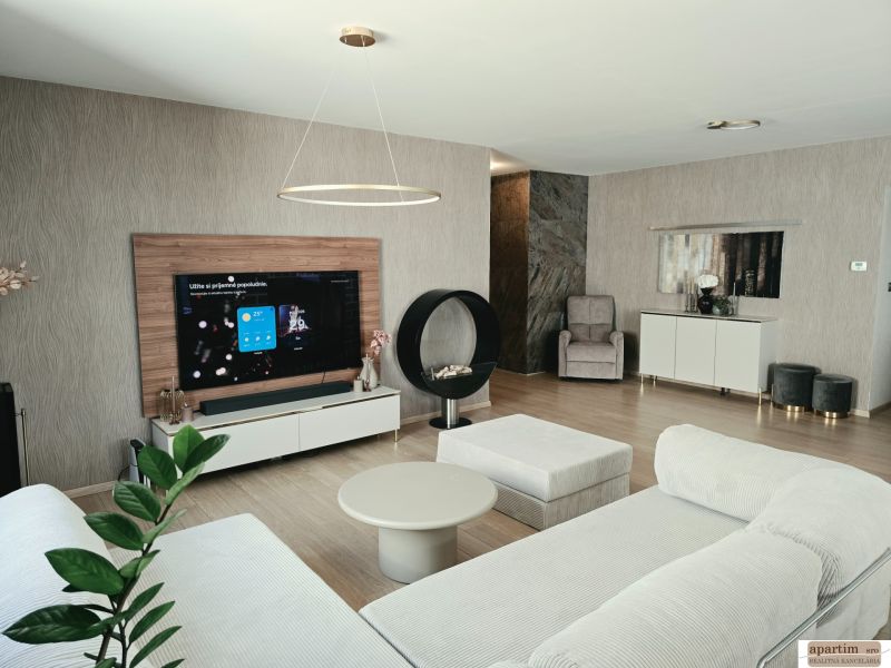 Wohnzimmer in einer 4-Zimmer-Wohnung mit Kamin, Sofa und Holzboden.