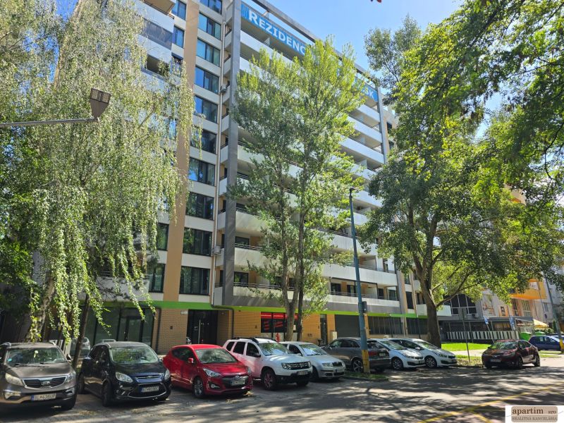 Ein Wohnhochhaus umgeben von Bäumen in der Antolská Straße in Bratislava, Petržalka.