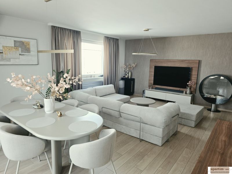 Ein stilvolles Wohnzimmer mit einem bequemen Sofa, einem Esstisch und einem Holzboden in einer 4-Zimmer-Wohnung.
