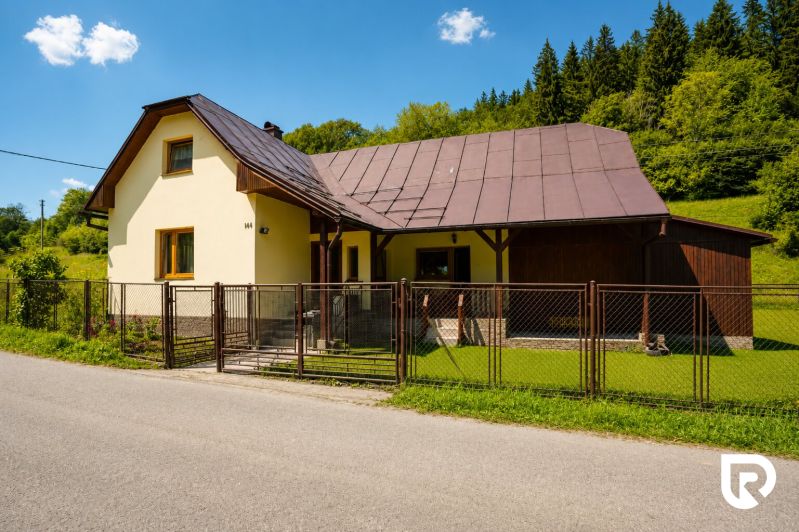 Ein Ferienhaus in der Straße Čierne in Makov mit einem Zier-Rasen und einem Holzzaun.
