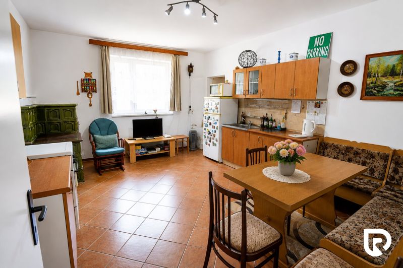 Küche in einem Einfamilienhaus mit Kamin, Möbeln und Dekorationen, Boden mit Holzdekor.