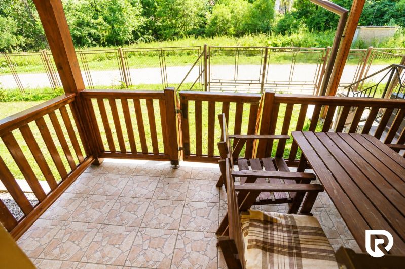 Eine Holzterrasse mit Blick auf den Garten in einem Einfamilienhaus.