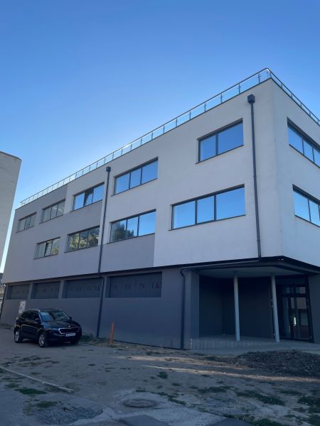 Gewerbeflächen in Levice in der Komenského 2A 2B mit verglasten Fenstern und einem geparkten Auto.