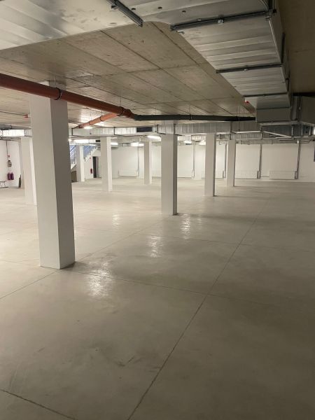 Geräumige Geschäftsräume mit großflächigem Boden und flacher Decke.