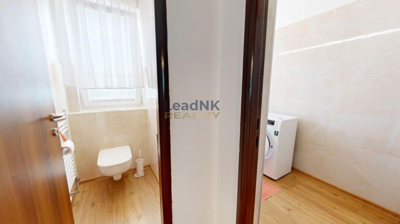 Badezimmer in einer 3-Zimmer-Wohnung mit WC, Waschmaschine und Holzboden.