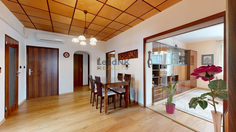 Esstisch und Stühle auf einem Boden mit Holzdekor in einer 3-Zimmer-Wohnung.