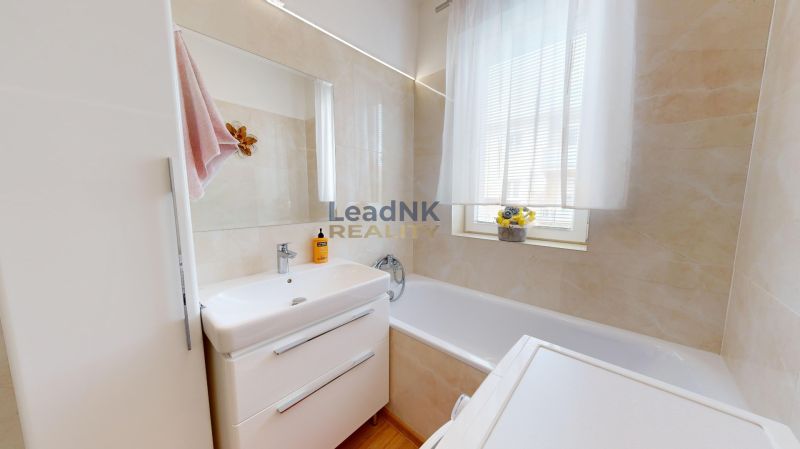 Badezimmer in einer 3-Zimmer-Wohnung mit Badewanne, Waschbecken und Stauraum.