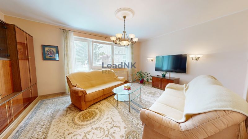 Wohnzimmer mit Teppichen, Sofas und Fernseher in einer 3-Zimmer-Wohnung.