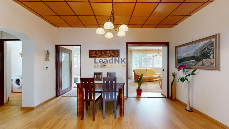 Esstisch und Stühle, Boden mit Holzdekor, Bild und Dekorationen in einer 3-Zimmer-Wohnung.