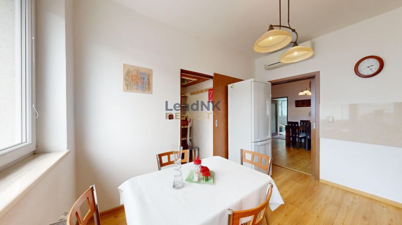 Küche in einer 3-Zimmer-Wohnung mit Holzboden, weißem Tisch und Stühlen.