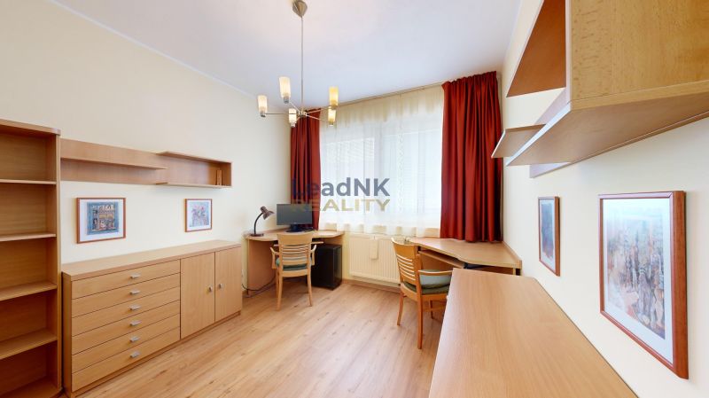 Ein Zimmer in einer 3-Zimmer-Wohnung mit einem Boden in Holzoptik und hellen Möbeln.