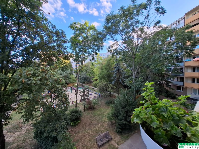 Blick vom Balkon einer 3-Zimmer-Wohnung in der Hospodárska-Straße in Trnava, mit Spielplatz und Bäumen.