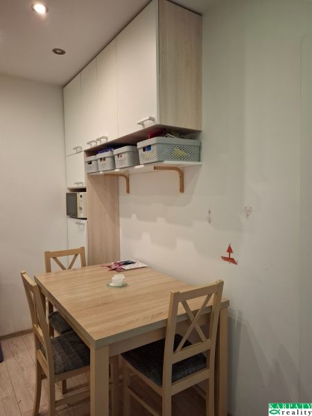 Essbereich mit Tisch und Stühlen in einer 3-Zimmer-Wohnung. Boden mit Holzdekor.