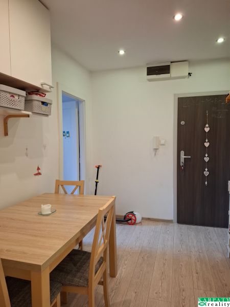 Esszimmer in einer 3-Zimmer-Wohnung mit Holzboden und Holztisch.