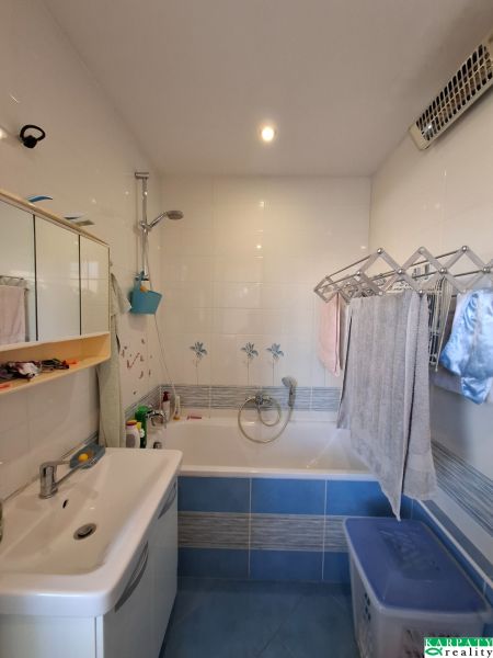 Badezimmer in einer 3-Zimmer-Wohnung mit Badewanne, Spiegelschrank und Fliesen.