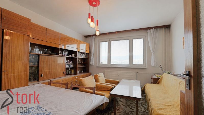 Wohnzimmer in einer 2-Zimmer-Wohnung mit Teppichmustern und gelben Sofas.