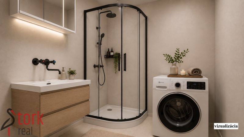 Badezimmer in einer 2-Zimmer-Wohnung mit Waschmaschine, Duschkabine und Waschbecken.