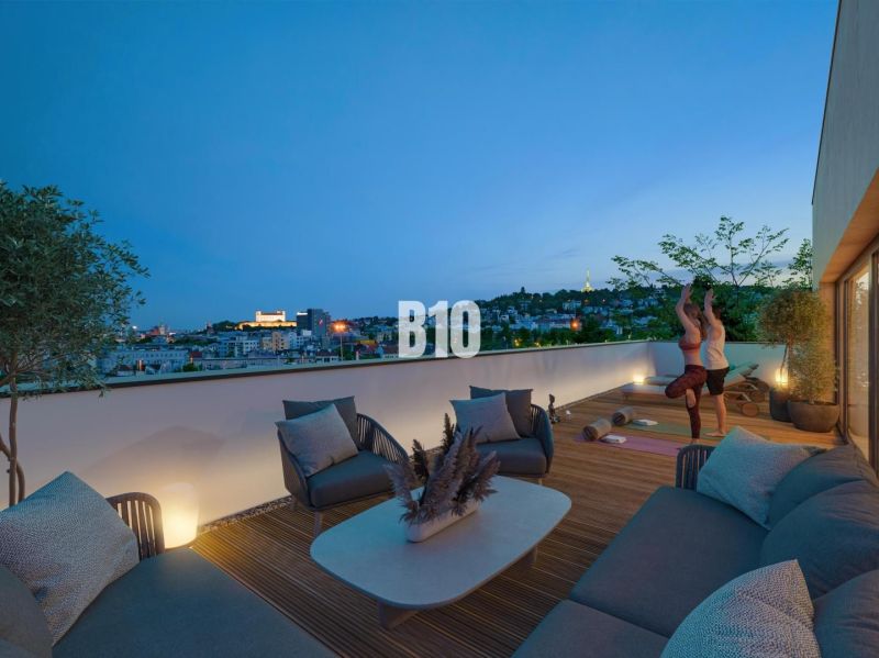 Eine Terrasse mit Blick auf die Stadt, bequeme Sitzgelegenheiten und ein Fitnessbereich in einer 3-Zimmer-Wohnung in Bratislava III, Pod Strážami.
