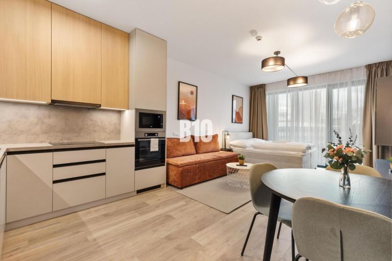 Küche und Wohnbereich einer Einzimmerwohnung mit Holzboden.