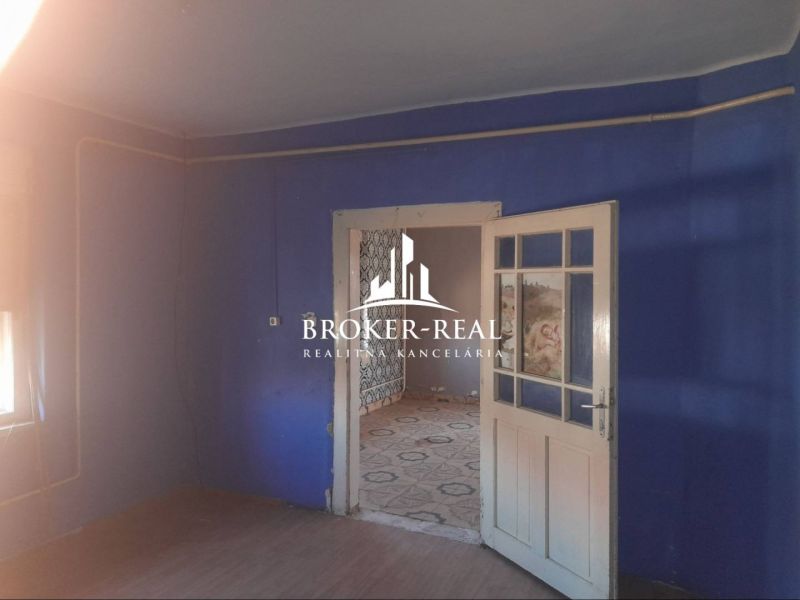 Blaues Zimmer in einem Einfamilienhaus mit Verbindungstüren und Holzboden.