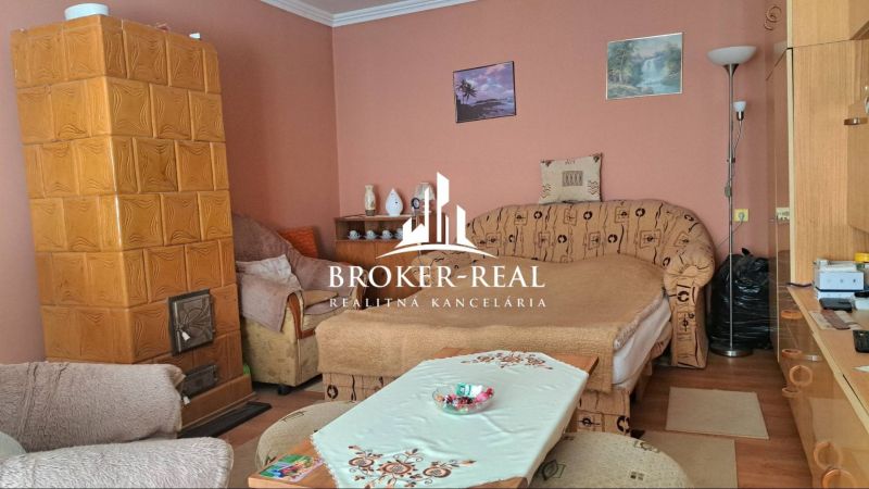 Wohnzimmer mit Kachelofen und Sofa in einem Einfamilienhaus.