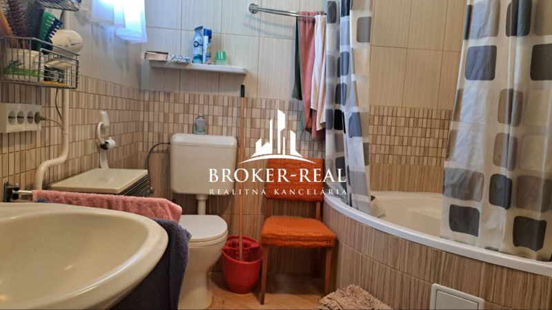 Ein Badezimmer in einem Einfamilienhaus mit einer Badewanne, einem Waschbecken und bunten Handtüchern.