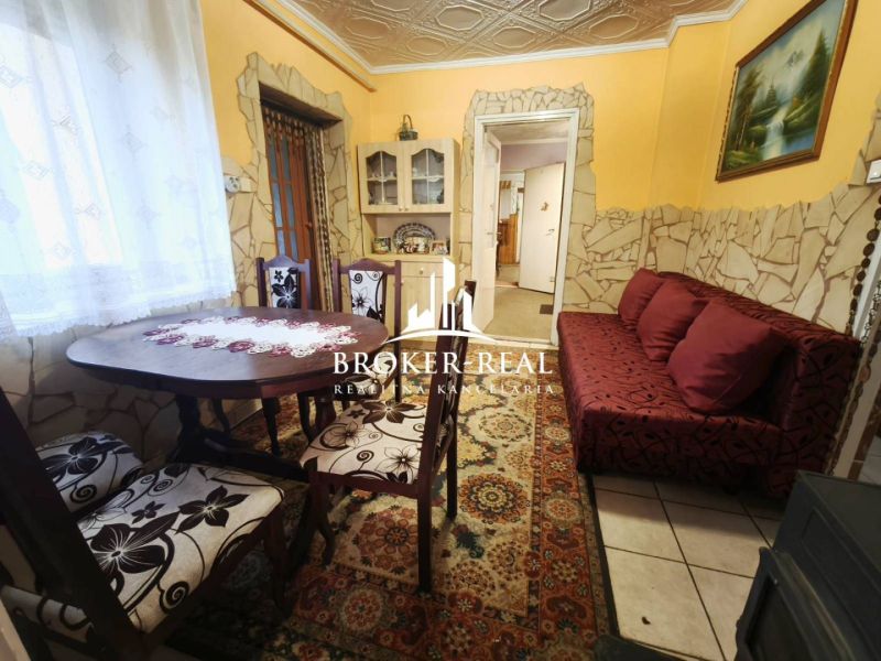 Esszimmer in einem Einfamilienhaus mit einem dekorativen Tisch und einem roten Sofa.