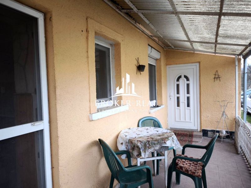 Die Terrasse eines Einfamilienhauses in Bódvaszilas mit einem Tisch und Plastikstühlen auf einem gepflasterten Boden.