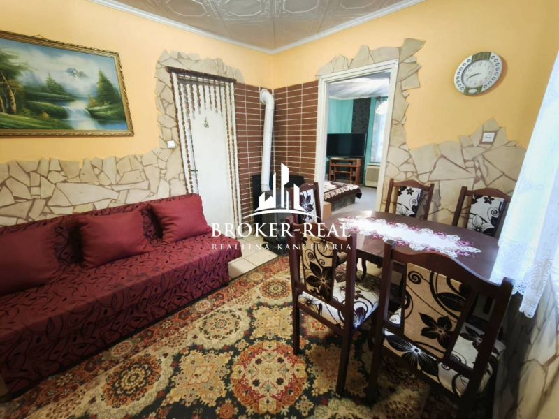 Wohnzimmer in einem Einfamilienhaus mit einem Naturbild und einem Holzesstisch.