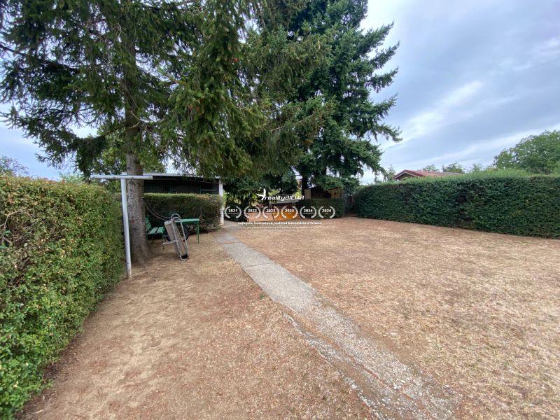 Der Garten beim Einfamilienhaus in der Zvončín-Straße in Zvončín, gesäumt von einer Hecke und Bäumen.