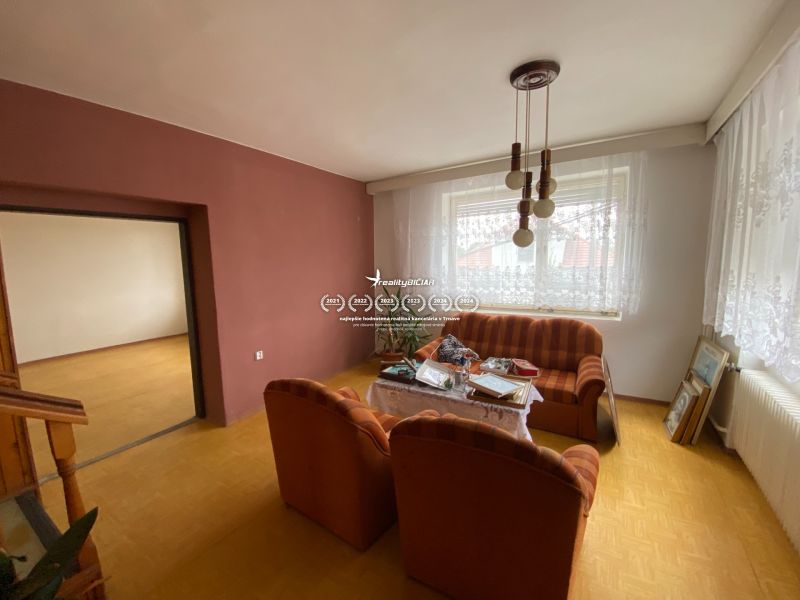 Wohnzimmer eines Einfamilienhauses mit Holzboden und gestreiftem Sofa.