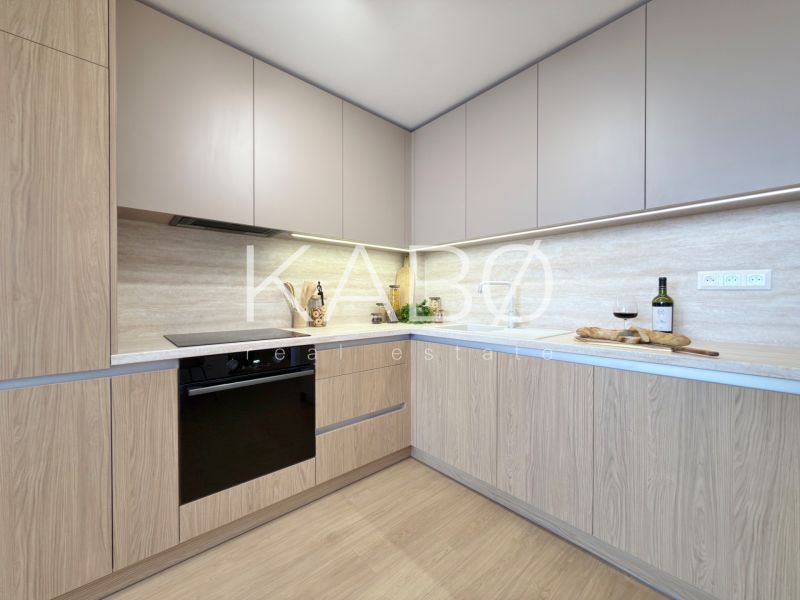 Küche in einer 3-Zimmer-Wohnung mit Holzboden und eingebauten Geräten.