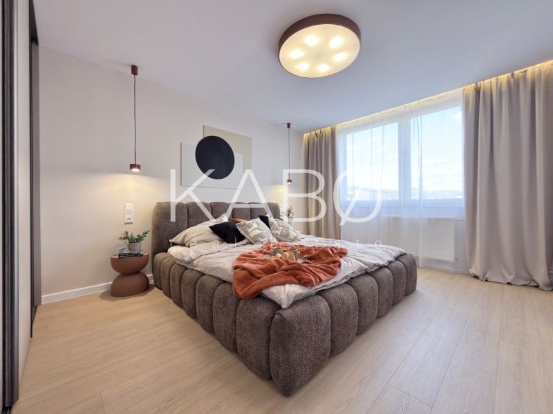 Helles Schlafzimmer mit großem Bett und Holzboden in einer 3-Zimmer-Wohnung.