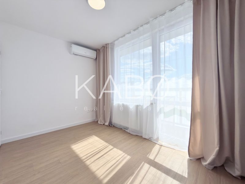 Ein Zimmer mit Holzboden und Klimaanlage in einer 3-Zimmer-Wohnung.