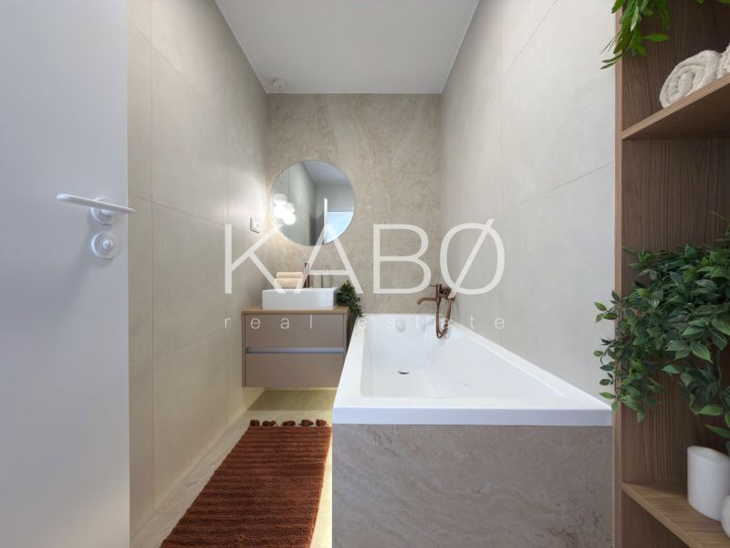 Badezimmer mit Badewanne und Waschbecken in einer 3-Zimmer-Wohnung mit beigen Wänden.