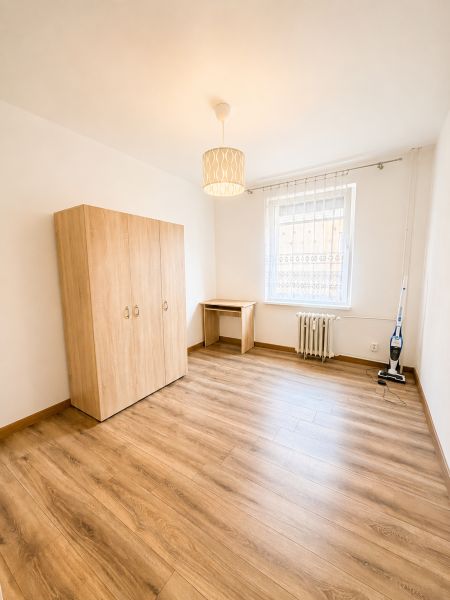 Ein geräumiges Zimmer mit einem Holzboden in einer 3-Zimmer-Wohnung.
