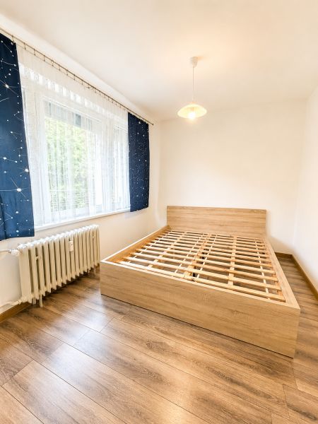 Schlafzimmer mit Holzboden und Bett in einer 3-Zimmer-Wohnung.