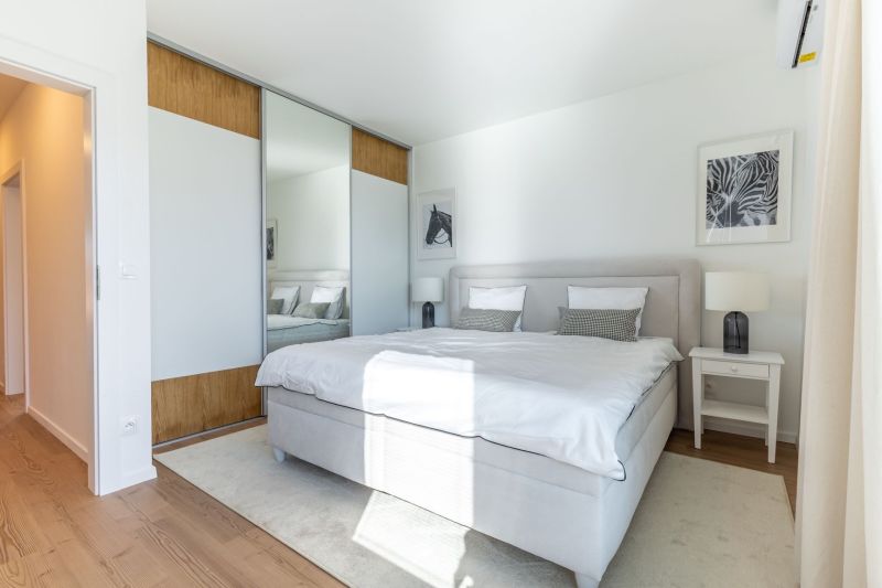 Helles Schlafzimmer im Einfamilienhaus mit großem Bett und Kleiderschrank.