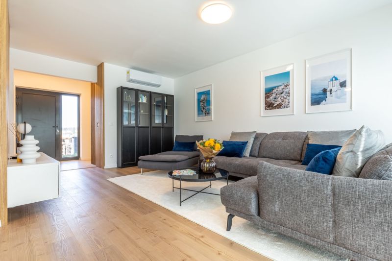 Wohnzimmer in einem Einfamilienhaus mit Holzboden, Sofa und Dekorationsgegenständen.